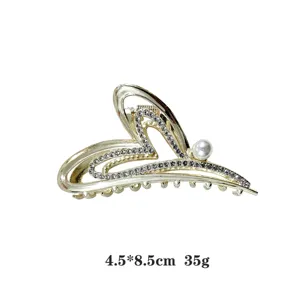 Gold hollow love heart hair claw clip with dazzling rhinestones and elegant pearl charm.