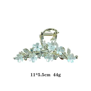 Elegant metal hair claw clip with white flowers and sparkly rhinestones for women styling.