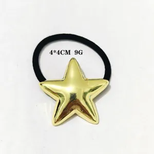 Nahaufnahme eines minimalistischen goldenen Stern-Haargummis mit schwarzem Gummiband, 4x4cm.