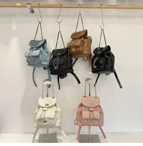 Detailed view of quilted chain backpacks in various colors, showcasing metal straps and locks.