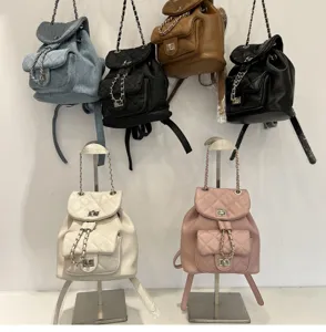 Multi-color quilted chain backpacks display showing various leather and denim styles.