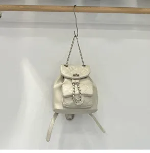 White quilted chain backpack detail, elegant PU leather shoulder bag with metal strap lock.
