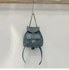 Detailed view of the stylish quilted denim backpack with chain straps and chic metal lock.