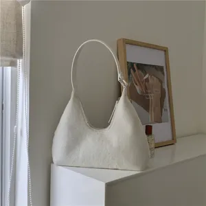 White plush crescent shoulder bag scene detail, soft fluffy fabric texture and elegant leather strap.