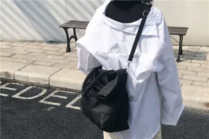Λεπτομερής εικόνα casual μαύρης τσάντας ώμου με χερούλια σχοινιού, στιλάτη και μεγάλη.