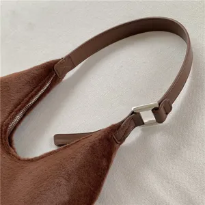 Close-up detail of soft brown plush hobo shoulder bag, PU leather strap with silver metal buckle.