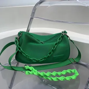 Green canvas underarm shoulder bag detail showing stylish chunky chain and textured fabric.