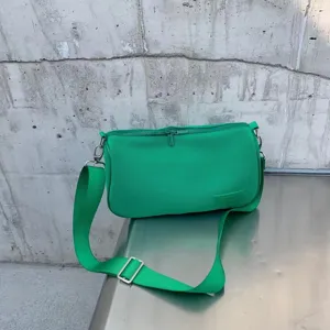Green fabric underarm shoulder bag detail view, casual commuting daily fashion accessory.
