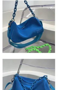 Blue textured shoulder bag with chunky chain strap and spare green braided strap, stylish.