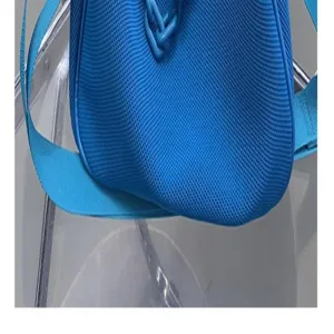 Blue woven shoulder bag detail view, stylish blue fabric material, fashion accessory accent.