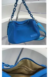 Blue canvas underarm shoulder bag with chunky chain strap and interior zipper pocket.
