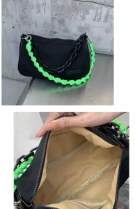 Black canvas underarm bag with neon green braided strap and chain, chic casual handbag.