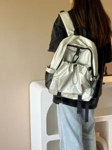 Sac à dos décontracté métallisé argenté avec multi-poches et cordon pour voyages.