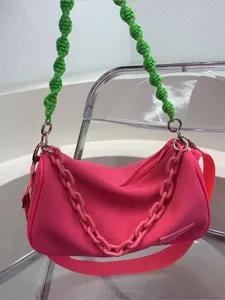 Stylish canvas underarm shoulder bag with neon pink body, green rope handle and chunky chain.