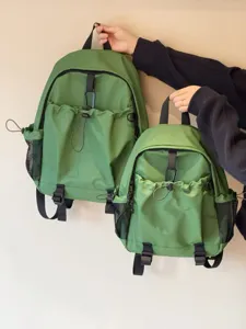 Vue détaillée du sac à dos vert à multiples poches avec cordon de serrage et poches latérales.