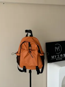 Sac à dos orange imperméable multi-poches détail, sac de voyage unisexe avec poches filet.