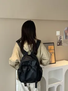 Vue détaillée d'un sac à dos étanche noir avec de multiples poches pour les loisirs.