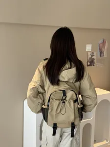 Sac à dos étanche de style neutre doté de poches multiples et d'un cordon pour les trajets.