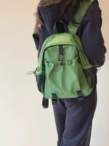 Vue rapprochée du sac à dos en nylon vert décontracté avec plusieurs poches et filets.
