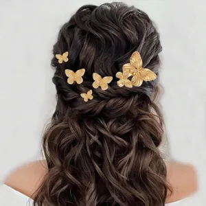 Detail shot showing elegant gold metal butterfly hair clips styled beautifully on wavy brown hair.