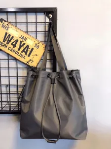 Detailed view of grey nylon drawstring tote bag highlighting dual straps and large capacity.