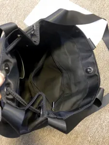 Large capacity black nylon shoulder tote bag with drawstring and zipper pockets for women.