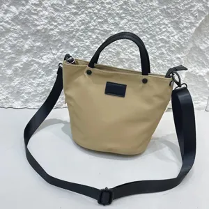 Waterproof nylon bucket shoulder bag, stylish casual crossbody handbag with black straps.