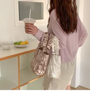 Detailed view of trendy pleated cloud shoulder bag in metallic bronze and white finish soft.