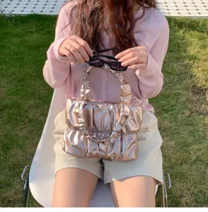 Detailed shot of trendy metallic pleated cloud handbag, soft pouch purse for stylish women outfit.