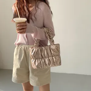 Detailed view of the trendy metallic ruched cloud handbag styled in casual outfit.