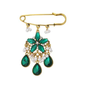 Detailed view of vintage bohemian green rhinestone safety pin brooch, retro alloy jewelry.