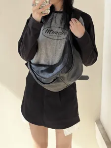 Détail de sac porté épaule souple en cuir, élégant sac croissant noir très tendance.