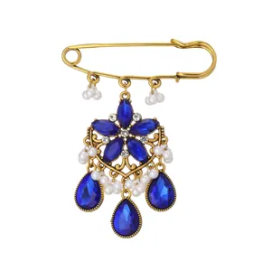 Vintage gold tone blue rhinestone safety pin brooch, bohemian chic crystal pearl jewelry detail.