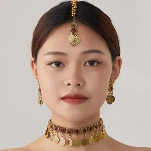Close-up of a bohemian ethnic gold coin choker necklace and earrings set with red gems.