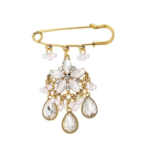 Close-up detail of vintage gold brooch with crystal rhinestones and pearls. Elegant and unique.