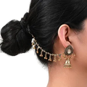 Gros plan détail de boucles d'oreilles jhumka indiennes vintage avec chaîne de cheveux.