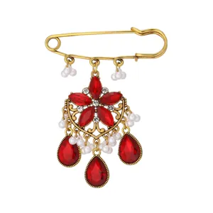Vintage red gemstone pearl brooch detail, bohemian metal safety pin jewelry accessory, elegant design.
