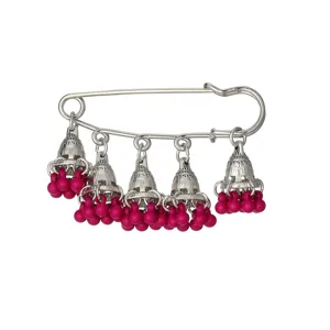 Close-up of vintage silver safety pin featuring intricate jhumka bells with vibrant pink beads.