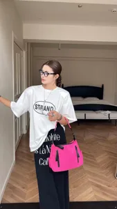 Detailed view of the stylish pink nylon shoulder bag in a modern indoor lifestyle setting.