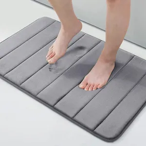 Detalle de alfombrilla de baño gris con textura rayada suave y superficie absorbente.