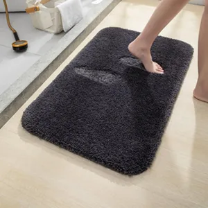 Detalle de alfombrilla de baño mullida gris oscuro con textura de felpa y orejas de conejo.