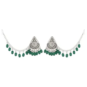 Detailed view of ethnic vintage silver ear chains with green beads and intricate metal carving.