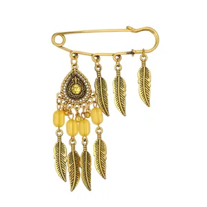 Vintage gold safety pin brooch featuring bohemian feather and yellow bead dangles for women.