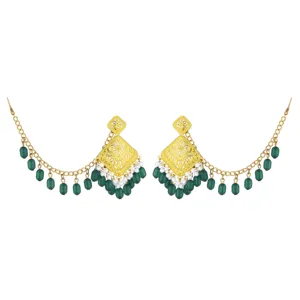 Detailed view of ethnic carved golden stud earrings with green bead tassels and delicate chain.