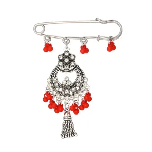 Nahaufnahme der Vintage ethnischen Strass Brosche mit roten Perlen und feiner Quaste.