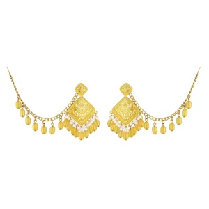 Close-up detail of ethnic carved hollow gold-plated earrings with yellow bead fringe.