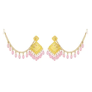 Detailed view of ethnic vintage gold-plated hollow carved earrings with pink bead fringe chains.