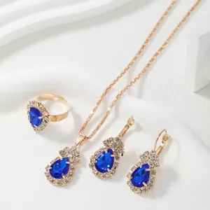 Luxury blue crystal teardrop necklace earrings ring set gold tone elegant jewelry detail view.