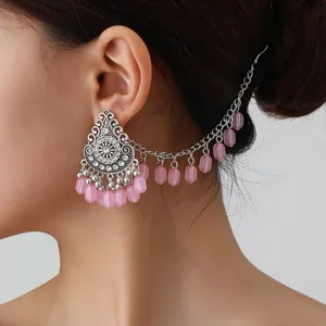 Detailed view of the bohemian style pink beaded ear chain and vintage silver earring piece.