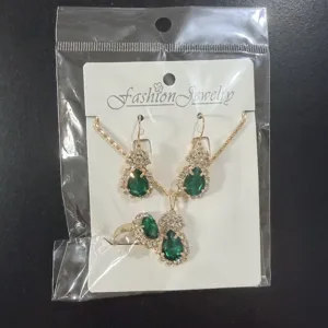 Detailed shot of shiny green teardrop rhinestone jewelry set necklace earrings ring.